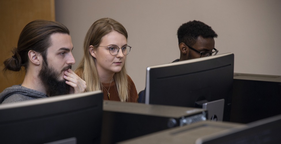 Studenter sitter i datorsal och arbetar med programmering under en lektion